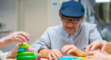 Elder man playing skill games in a nursing home